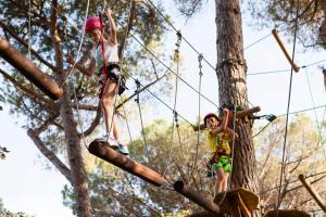 two children are climbing on a tree at Pigna Felice Punta Ala in Punta Ala