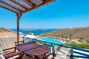 a balcony with a table and chairs and a swimming pool at Sunrise Beach Suites in Azolimnos Syros +42 photos