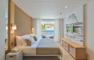 a bedroom with a bed and a view of the ocean at Canonnier Beachcomber Golf Resort & Spa in Pointe aux Cannoniers