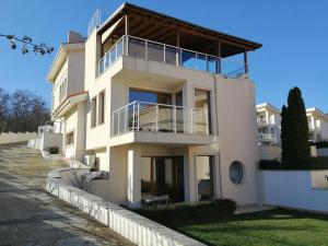 a white house with a balcony on the side of it at Wonderful family villa with sea view in Byala