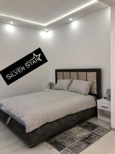 a bedroom with a bed with a sign on the wall at Apartman Silver Star in Sombor