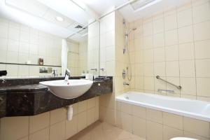 a bathroom with a sink and a bath tub at Luxury Escapes - Studio in JLT X1 Tower close to Metro in Dubai
