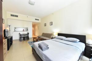 a bedroom with a large bed and a living room at Studio in JLT X1 Tower close to Metro - DB in Dubai