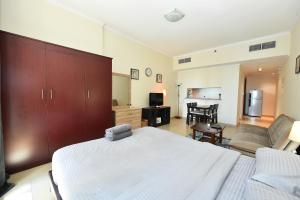 a bedroom with a large bed and a living room at Luxury Escapes - Studio in JLT X1 Tower close to Metro in Dubai