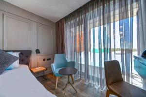 a bedroom with a bed and a large window at Land's End, Boutique Hotel in Sliema