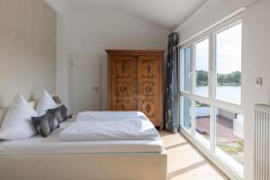 ein Schlafzimmer mit einem Bett und einem großen Fenster in der Unterkunft Wiekhaus am See in Lychen