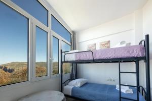 sypialnia z 2 łóżkami piętrowymi i oknem w obiekcie Vourvahis Seaview Apartments w mieście Karotí