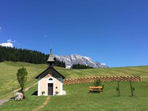 une petite chapelle dans un champ avec une montagne en arrière-plan dans l'établissement Chalet in Maria Alm in ski area with sauna, à Maria Alm