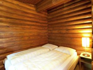 ein Schlafzimmer mit einem Bett in einer Holzwand in der Unterkunft Chalet in W rgl Boden in the Brixental in Salvenberg