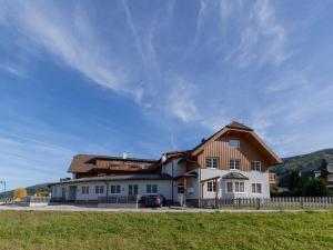 una grande casa bianca con tetto in legno di Apartment in St Margarethen with balcony a Sankt Margarethen im Lungau