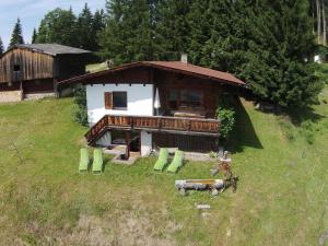 une maison sur une colline avec un cheval devant elle dans l'établissement Chalet in Hopfgarten Brixental in ski area, à Hopfgarten im Brixental