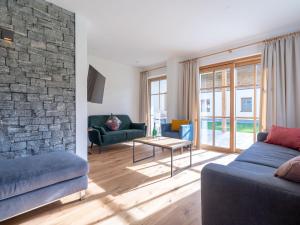 a living room with two blue couches and a brick wall at Luxury chalet in Bad Hofgastein with sauna in Bad Hofgastein