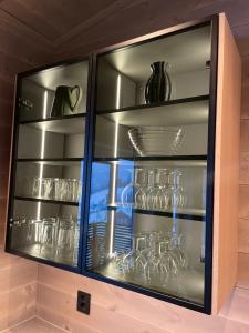 a glass cabinet filled with glasses and vases at Panorama 17 - fantastisk utsikt! in Sogndal
