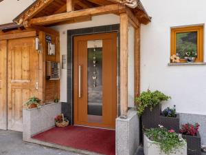 a front door of a house with a wooden entrance at Land on the KPPL mountain chains in Kappl