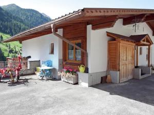 a house with a wooden door and a patio at Land on the KPPL mountain chains in Kappl