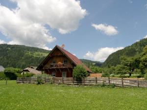 ein Holzhaus auf einem Feld neben einem Zaun in der Unterkunft Chalet in Stadl an der Mur Styria with sauna in Einach