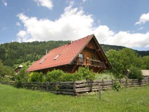 Cabaña de madera con techo rojo en un campo en Chalet in Stadl an der Mur Styria with sauna en Einach