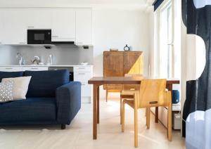 a living room with a table and a blue couch at Stylish new 1br apt in Aurinkolahti in Helsinki
