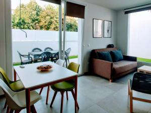 a living room with a table and chairs and a couch at VivaBien Playa I - Apartamentos junto al mar in Benicàssim