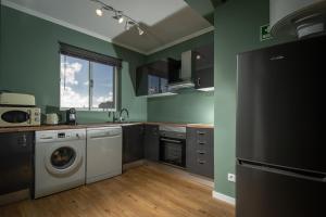 a kitchen with green walls and a washer and dryer at TOI ET MOI DOWNTOWN-Guests speek for us! in Ponta Delgada