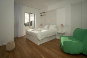 a bedroom with a bed and a green chair at TOI ET MOI DOWNTOWN-Guests speek for us! in Ponta Delgada