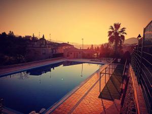 a large swimming pool with a sunset in the background at Casa la Canal in Cabacés