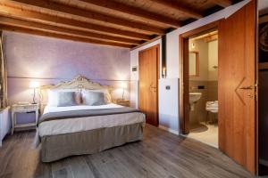 a bedroom with a king sized bed and a bathroom at V nice rooms in Venice