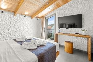a hotel room with a bed and a tv at Emily's Luxury Suites in Pefkochori
