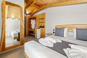 a bedroom with two beds and a mirror at Emily's Luxury Suites in Pefkochori