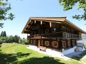 a large wooden building on a grassy field at Chalet on the ski slope in St Johann in Tyrol in Apfeldorf