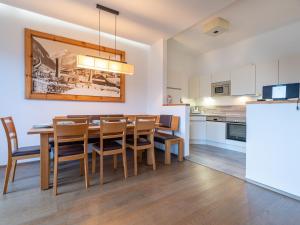 cocina y comedor con mesa y sillas en Luxurious Apartment in F rth with Pool en Piesendorf