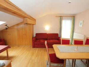 een woonkamer met een rode bank en een tafel bij Quaint Apartment in L ngenfeld with Sauna in Huben