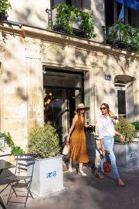 a man and a woman walking out of a store at Hôtel de Banville in Paris