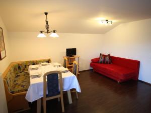 a living room with a table and a red couch at Modern Chalet in Wagrain with Balcony in Wagrain