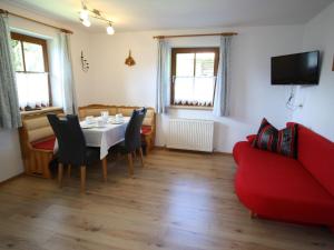 a dining room with a table and a red couch at Modern Chalet in Wagrain with Balcony in Wagrain