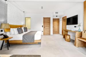 a bedroom with a king sized bed and a tv at Emily's Luxury Suites in Pefkochori