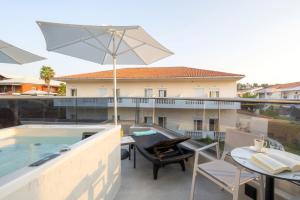 a patio with a table and an umbrella at Emily's Luxury Suites in Pefkochori