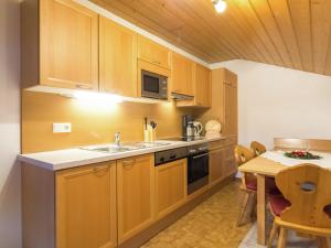 cocina con armarios de madera y mesa de cocina con mesa en Apartment near the ski area in Wagrain en Wagrain