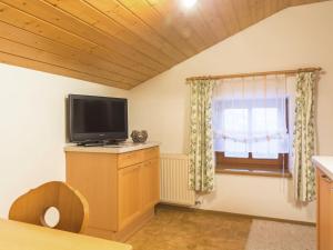 ein Wohnzimmer mit einem TV und einem Fenster in der Unterkunft Apartment near the ski area in Wagrain in Wagrain