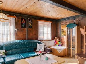 a living room with a green couch and a table at Holiday house in East Tyrol near ski area in Matrei in Osttirol