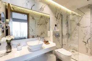 a bathroom with a sink and a toilet and a shower at Emily's Luxury Suites in Pefkochori