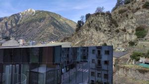 un bâtiment avec une montagne en arrière-plan dans l'établissement SUITEDREAMS - Feixa 41, à Andorre-la-Vieille