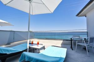 a balcony with a table and an umbrella at Emily's Luxury Suites in Pefkochori