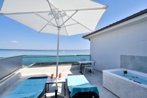 a patio with an umbrella and a bath tub at Emily's Luxury Suites in Pefkochori