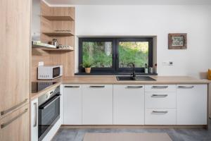 a kitchen with white cabinets and a window at Chata Večernica in Liptovský Mikuláš