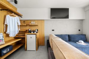 Habitación con cama, sofá y TV. en Emily's Luxury Suites en Pefkohori