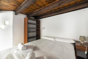 a bedroom with a white bed with towels on it at Porta Romana & Bocconi Cosy Apartment in Milan +9 photos