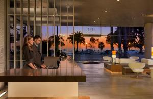 a man and woman standing in a lobby with a laptop at Shore Hotel in Los Angeles +52 photos