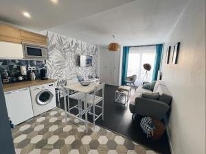 a kitchen and living room with a couch and a table at NEW: appartement tout confort + parking gratuit in Amiens