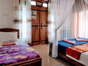 a bedroom with two beds and a window with curtains at Ella Mount Villa in Ella